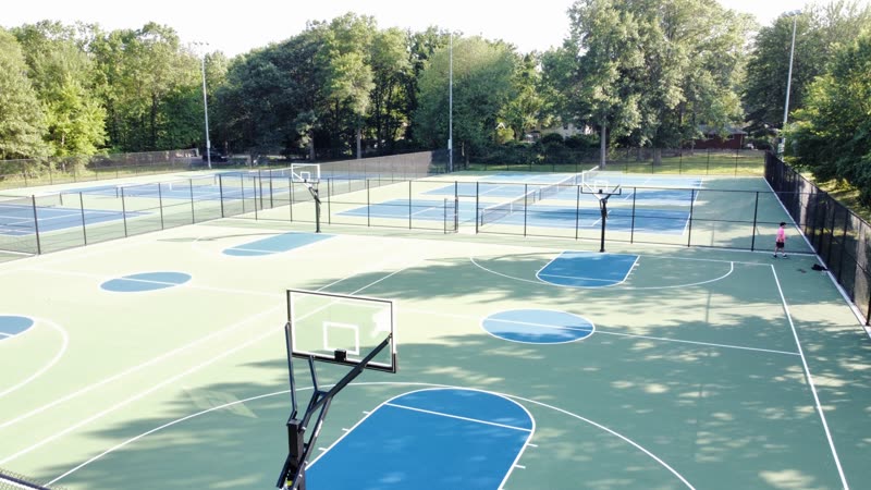 Black chain link fence beside a basketball court