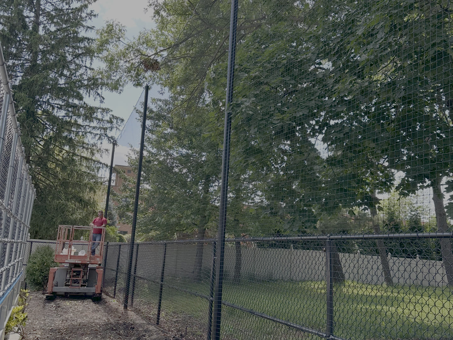 Chain link fence posts being set in a yard