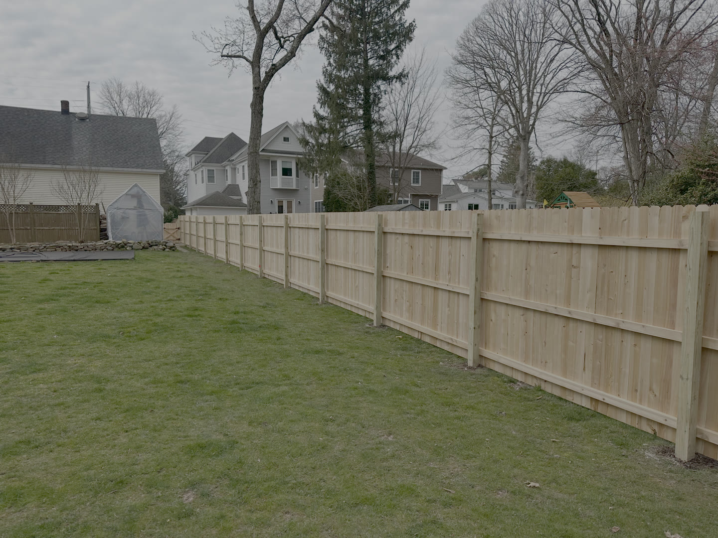 Cedar privacy fence along a backyard lawn