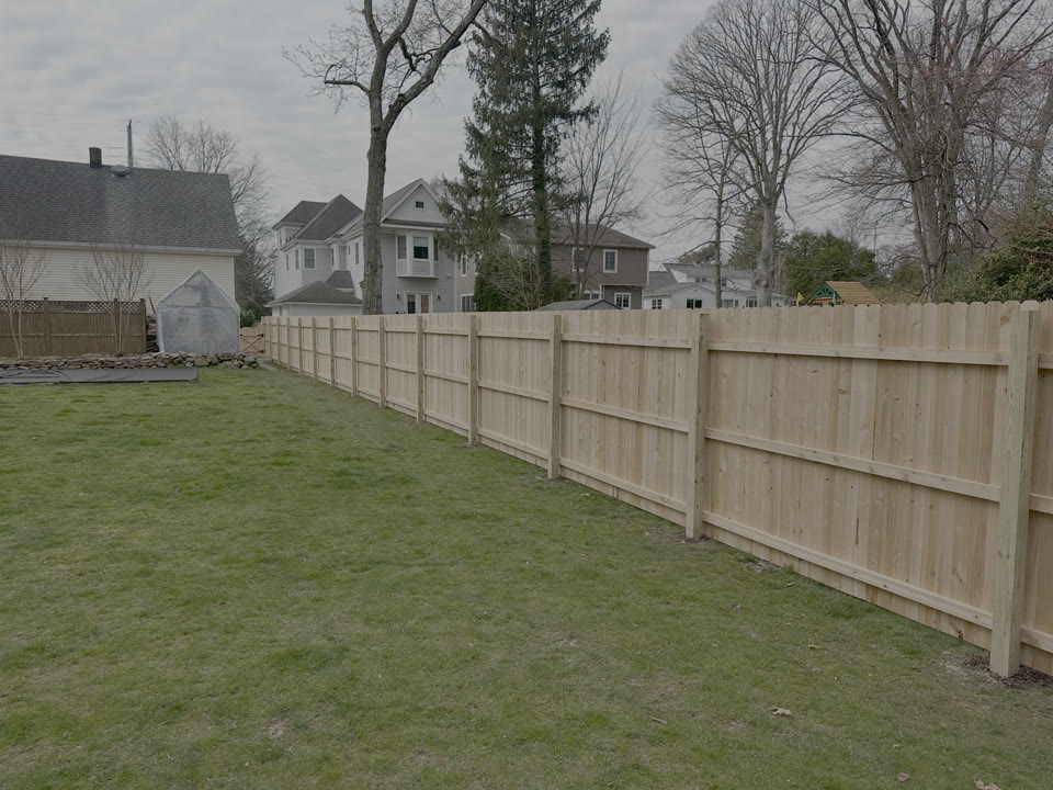 Cedar privacy fence along a green lawn