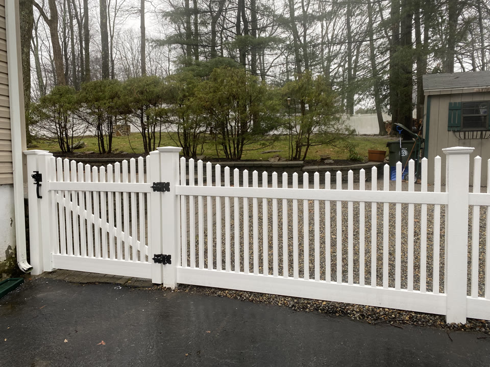 White vinyl picket fence with a walk gate